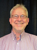 Tom Dowling: a smiling white older man wearing glasses, a button down shirt
